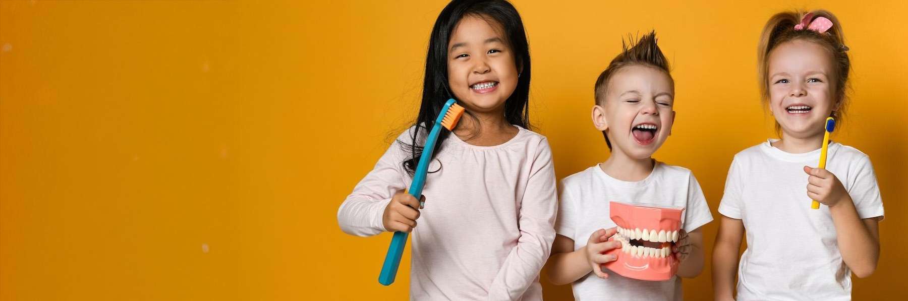 Kids smiling and holding toothbrushes, pascoe vale vic