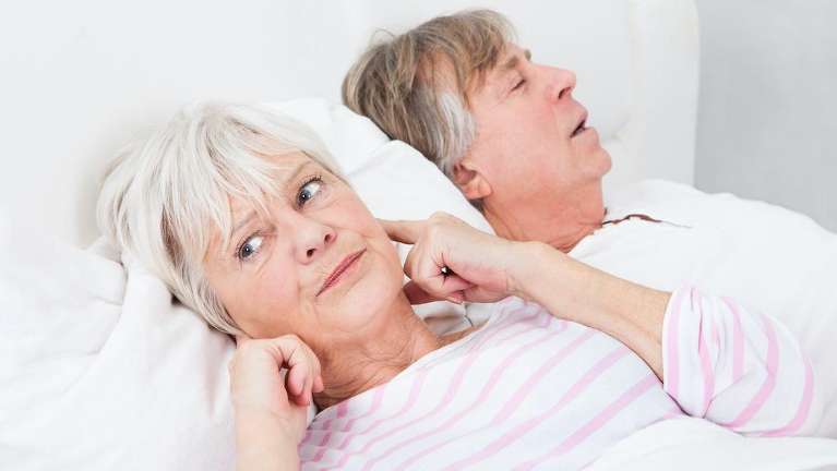 Old woman plugging her ears next to a man in bed, pascoe vale vic