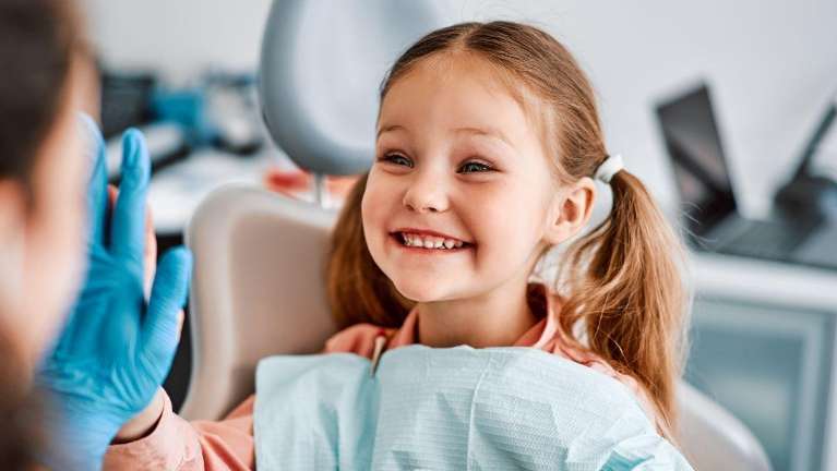 Young girl smiling and giving a highfive to a dentist, pascoe vale vic